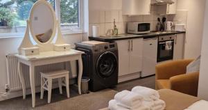een keuken met een wasmachine en een wastafel bij Charming Studio Rutland Point holiday or work in Oakham