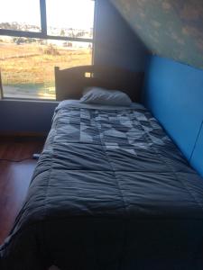 a large bed in a room with a window at casa sergio in Punta Arenas