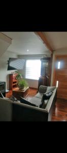 a living room with a couch and a window at casa sergio in Punta Arenas