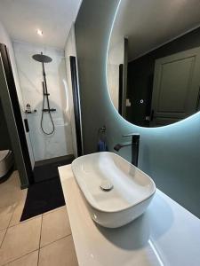 y baño con lavabo blanco y espejo. en LICHEN, Superbe vue sur le Rhône ! 3 Chambres, en Tain-lʼHermitage