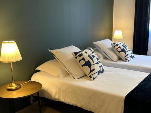 1 dormitorio con 2 camas con almohadas y lámpara en LICHEN, Superbe vue sur le Rhône ! 3 Chambres, en Tain-lʼHermitage