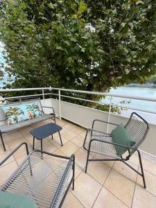 un patio con 2 sillas y un banco en el balcón en LICHEN, Superbe vue sur le Rhône ! 3 Chambres, en Tain-lʼHermitage