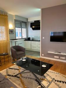 a living room with a black coffee table and a television at Appartement central in Toulouse