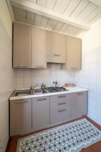 una cocina con armarios blancos y fregadero en Odi et Amo - Luxury Love en Brescia