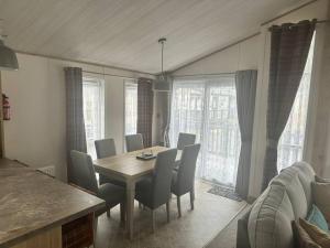 a dining room with a table and chairs at Luxury 6-8 Berth Lodge in New Milton
