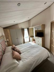 a bedroom with a large bed with pillows on it at Luxury 6-8 Berth Lodge in New Milton
