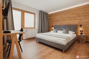 a bedroom with a bed and a desk and a television at Stoacherhof Apartments in Matrei am Brenner