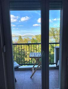 a balcony with a table and a view of the water at Duga Apartments in Novi Sad