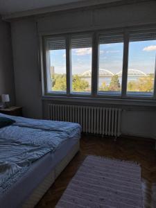a bedroom with a bed and a window with a view at Duga Apartments in Novi Sad