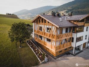an overhead view of a wooden house with mountains in the background at Stoacherhof Apartments in Matrei am Brenner