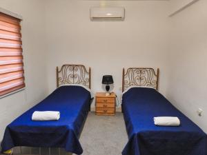 sypialnia z 2 łóżkami i stolikiem nocnym z lampką w obiekcie Beit Philodemus w mieście Um Qeis