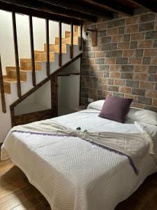 uma cama num quarto com uma parede de tijolos em Tradicional Casa Canaria con piscina y vistas al Teide em Icod de los Vinos