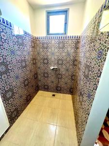 y baño con ducha y pared de azulejos. en Le Domaine de Carole Marrakech, en Akkara
