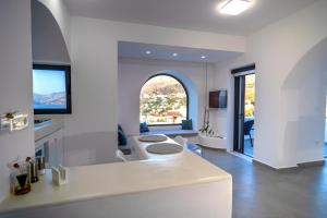 a white kitchen with an arched window and a sink at Shape-Meander in Kalymnos