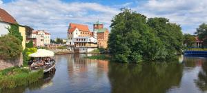 a boat traveling down a river in a city at Gościniec & SPA Darłowo in Darłowo