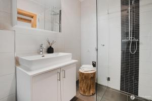 a white bathroom with a sink and a shower at Stoacherhof Apartments in Matrei am Brenner
