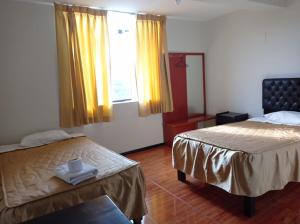 a hotel room with two beds and a window at hospedaje kayros in Arequipa