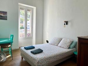 een slaapkamer met een bed en een raam bij Authentique T3 calme entre mer et Calanques in Marseille