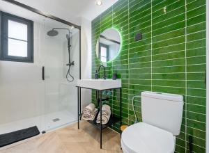 een badkamer met groene betegelde muren en een wit toilet bij Casa Pretori in Tarragona