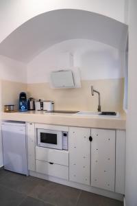 a white kitchen with a sink and a microwave at Shape-Meander in Kalymnos
