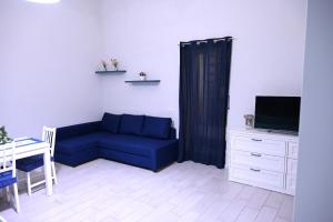 uma sala de estar com um sofá azul e uma televisão em Casa Don Renato em Nápoles