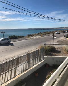 a view of a road and the ocean from a balcony at Vista al Mar in Puerto Madryn