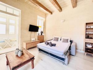 a bedroom with a bed and a tv and a table at COFFEE LOFT - Grand Master Palace in Valletta