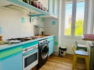 een keuken met een fornuis en een wasmachine bij Authentique T3 calme entre mer et Calanques in Marseille