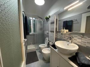 y baño con 2 aseos, lavamanos y ducha. en Eva Capital Guest House, en Vitinia