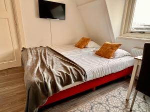 a bed in a room with a tv on the wall at Church Square Studio in Zandvoort