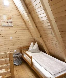a bed in a wooden room in a cabin at Konak kod Tose in Banja Luka