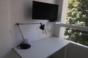 Cette chambre comprend un bureau avec une télévision et une lampe. dans l'établissement Studio Gare, Europole, à Grenoble