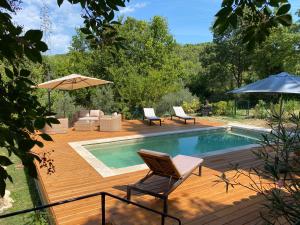 einen Pool mit 2 Stühlen und einem Sonnenschirm in der Unterkunft Otarkia in Vaison-la-Romaine