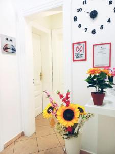 ein Zimmer mit einer Blumenvase und einer Uhr an der Wand in der Unterkunft B&B Family - Affitta camere in Reggio di Calabria