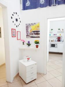 eine Küche mit weißen Wänden und einer Uhr an der Wand in der Unterkunft B&B Family - Affitta camere in Reggio di Calabria