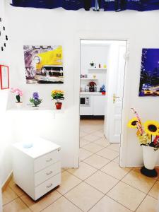 eine Küche mit weißen Wänden, einem weißen Tisch und Blumen in der Unterkunft B&B Family - Affitta camere in Reggio di Calabria
