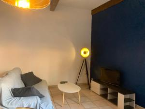 - un salon avec un canapé, une télévision et une table dans l'établissement Le Cosy de la Vieille Intendance, à Perpignan