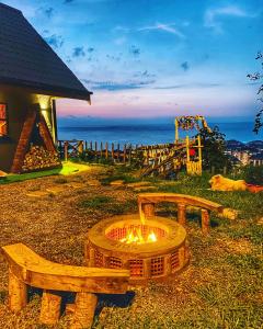 eine Feuerstelle mit zwei Bänken am Meer in der Unterkunft Lavinya Suit Bungalov in Rize