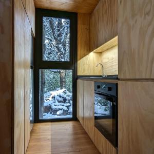 a kitchen with a window and a sink and a stove at El Bosque in San Carlos de Bariloche