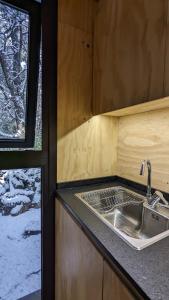 uma cozinha com um lavatório e uma janela em El Bosque em San Carlos de Bariloche