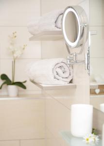 een badkamer met een spiegel en handdoeken op planken bij Appartements Diana in Millstatt