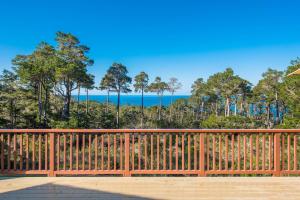 a wooden fence with a view of the ocean at 3707 Pacific's Edge Sanctuary home in Carmel