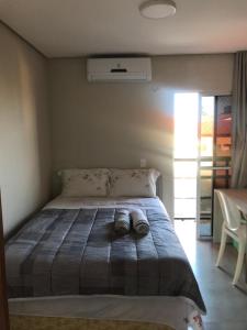 een slaapkamer met een bed met schoenen erop bij Excelente apartamento Villamares in Luis Correia