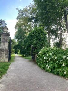 a brick path in a park with a gate and flowers at Chez Roya in Zaventem