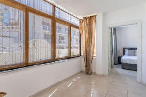 Habitación con ventanas grandes, 1 cama y 1 dormitorio. en Large Terrace Penthouse Sliema, en Sliema