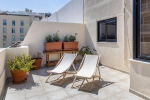 2 sillas y una mesa en un balcón con plantas en Large Terrace Penthouse Sliema, en Sliema