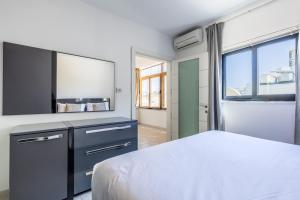 1 dormitorio con cama y espejo grande en Large Terrace Penthouse Sliema, en Sliema