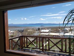 a view from the balcony of a house with a window at CABAÑA M&M in El Calafate