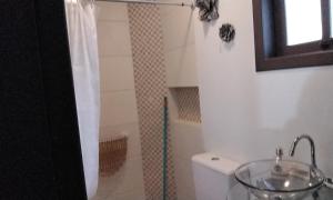 y baño con aseo, lavabo y ducha. en Tenda Caiu do Céu, en Osório