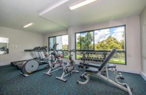 a gym with cardio equipment and a large window at The Regency Cosy Apartment- 419 in Pretoria